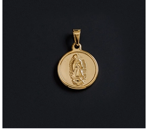 Macro detail of a vintage 18K gold plated coin pendant featuring religious relief art