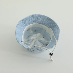 Detail of baby denim bucket hat showing red cherry embroidery and adjustable chin strap