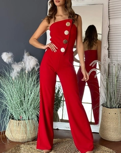 Detail of red strapless jumpsuit featuring four large gold buttons and wide-leg cut
