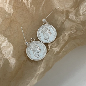 Detailed view of silver coin stud earrings featuring Queen Elizabeth embossed profile