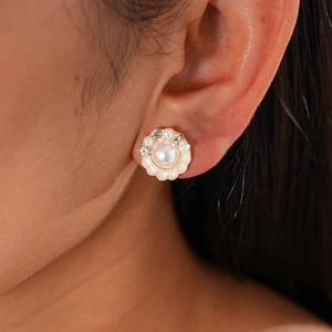 Close-up of vintage flower earring with large center pearl and sparkling rhinestone trim