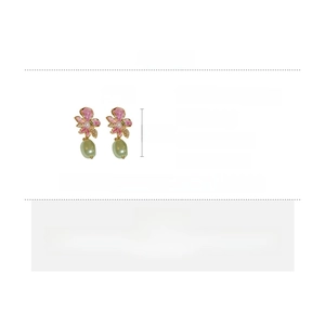 Detailed view of flower earrings with pink petals, crystals, and green resin beads
