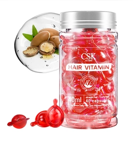 Macro view of red hair vitamin capsules in a 40ml bottle with Moroccan nut oil essence