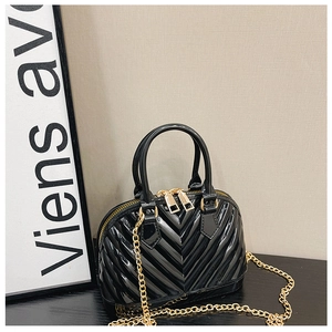 Detailed macro of black shell-shaped jelly bag with V-shaped quilting and gold hardware