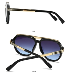 Detail view of modern oversized sunglasses with gold metal temples and gradient lenses