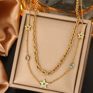 Détail du collier double couche plaqué or 18K avec œil bleu et breloques en étoile