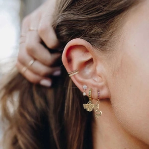 Detail showing gold bee earrings and snake studs set with green and red zircon stones