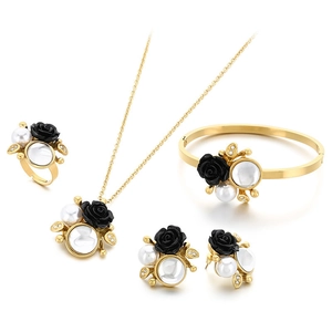 Elegant gold-tone jewelry set with black 3D rose charms and white pearl accents on white background