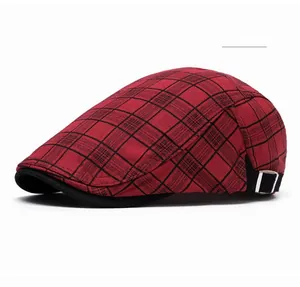 Detail of red plaid newsboy cap showing silver buckle and cotton fabric texture