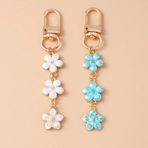 Floral cherry blossom keychains with pearl accents and enamel charms on gold rings