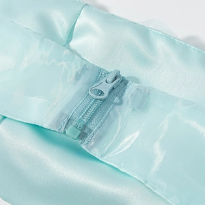 Détail d'une fermeture éclair invisible sur satin bleu clair avec texture en maille
