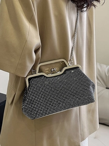 Elegant black shell evening bag with crystals and metal chain strap held by model