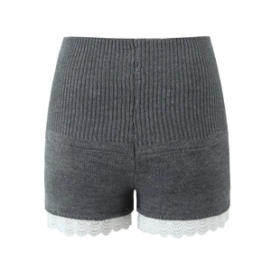 Détail du short gris en maille avec une bordure en dentelle blanche sur l'ourlet