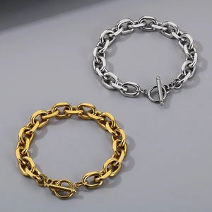 Detail of gold and silver thick chain bracelets with T-bar toggle clasp on grey background