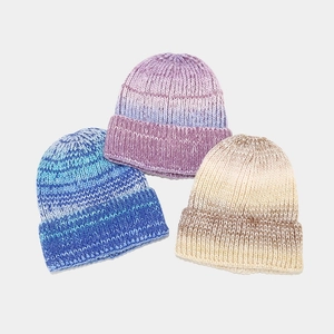 Vue détaillée de trois bonnets en tricot tie-dye montrant la texture dégradée et douce