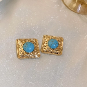 Detail of vintage square gold earrings featuring green turquoise stone and baroque carvings