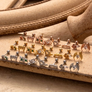Collection of stainless steel heart and wing piercing studs in gold and silver finishes