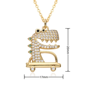 Detailed macro view showing a 20mm by 17mm gold dinosaur pendant with crystal inlay