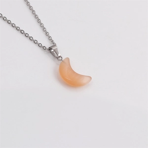 Gros plan détaillé d'un pendentif lune en pierre œil de chat orange sur chaîne argent