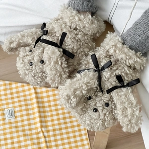 Détail de la texture pelucheuse en laine d'agneau avec design chiot et nœud décoratif