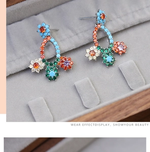 Macro shot of colorful zircon flower earrings on a velvet jewelry tray