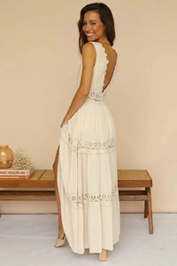 Detail of elegant V-neck lace dress showing the intricate open back and tiered hollow design