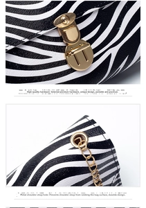 Detail of zebra pattern bag featuring golden twist lock and metal chain hardware