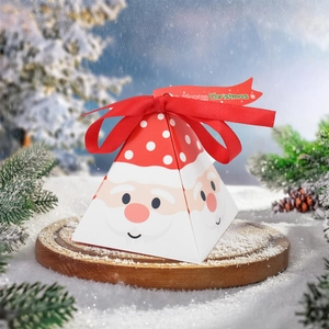 Detail of pyramid Christmas gift box with Santa motif and red ribbon on snowy wood