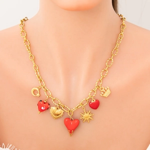 Detail of 18k gold plated necklace featuring red enamel hearts and celestial charms