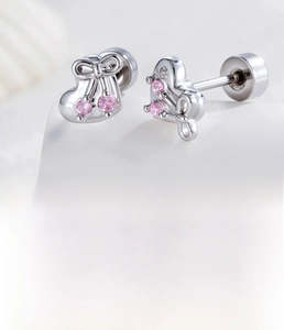 Detail of silver heart stud earrings with pink zircon bow and secure screw back closure
