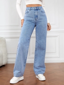 Détail du jean droit à taille haute montrant le délavage bleu et la coupe élastique