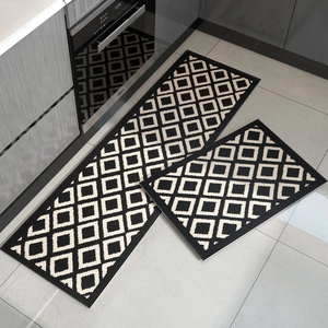 Kitchen mat set of 2 in black with beige geometric patterns on a tiled floor