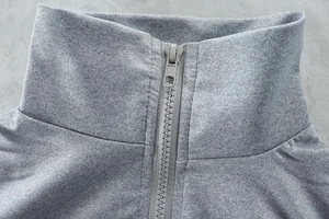 Detail of the high-quality gray knit fabric and sturdy zipper on the stand-up collar