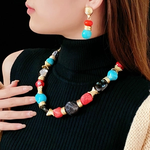 Close-up of vintage irregular necklace and earrings with turquoise and coral beads on a model