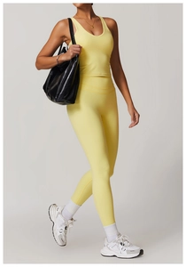 Detail view of pale yellow V-neck yoga tank top and high-waist leggings on model