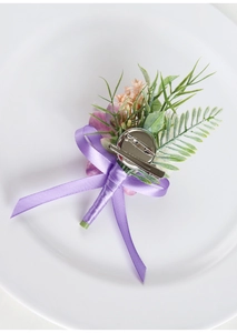 Detail showing the dual-use metal pin and clip on the back of a purple floral boutonniere