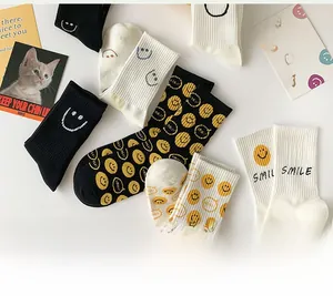 Close-up of stacked cotton crew socks with smile embroidery and printed letters