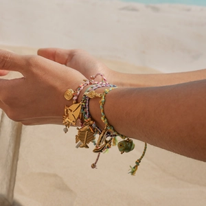 Colorful nautical braided rope bracelet with golden sea shell and anchor charms on wrist