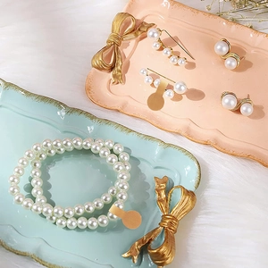 Flat lay of pearl jewelry set including brooch, earrings and bracelet on plush background