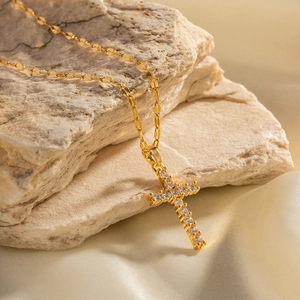 Detailed close-up of 18K gold-plated cross pendant with white zircon on a lip link chain
