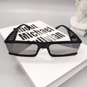 Detail of square black sunglasses on a book with a decorative plaster statue background