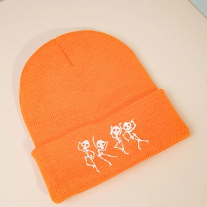 Détail de la broderie squelettes dansants sur un bonnet en maille côtelée orange
