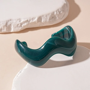 Detailed view of dark green acrylic resin bangle with marble texture and wavy design