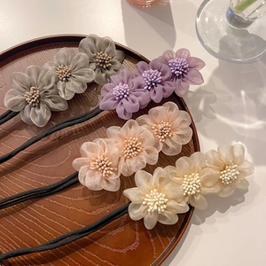 Set di quattro elastici per capelli con fiori grigio, viola, rosa e beige su vassoio