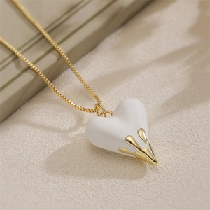 Fashionable gold chain necklace featuring a white heart pendant with melting metal detail