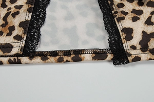 Close-up of leopard print fabric with black lace trim and reinforced stitching detail