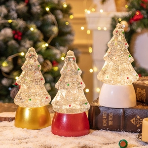 Christmas tree crystal ball music boxes with gold red and white bases in a festive setting