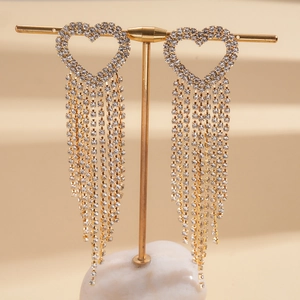 Detail of long heart tassel earrings with sparkling rhinestones on golden stand