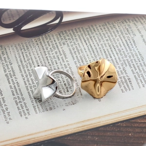 Details von Gold- und Silberknotenringen auf Buchseiten mit poliertem Wellenfinish