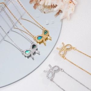 Elegant gold and silver butterfly necklaces with shell inlays on a mirror surface